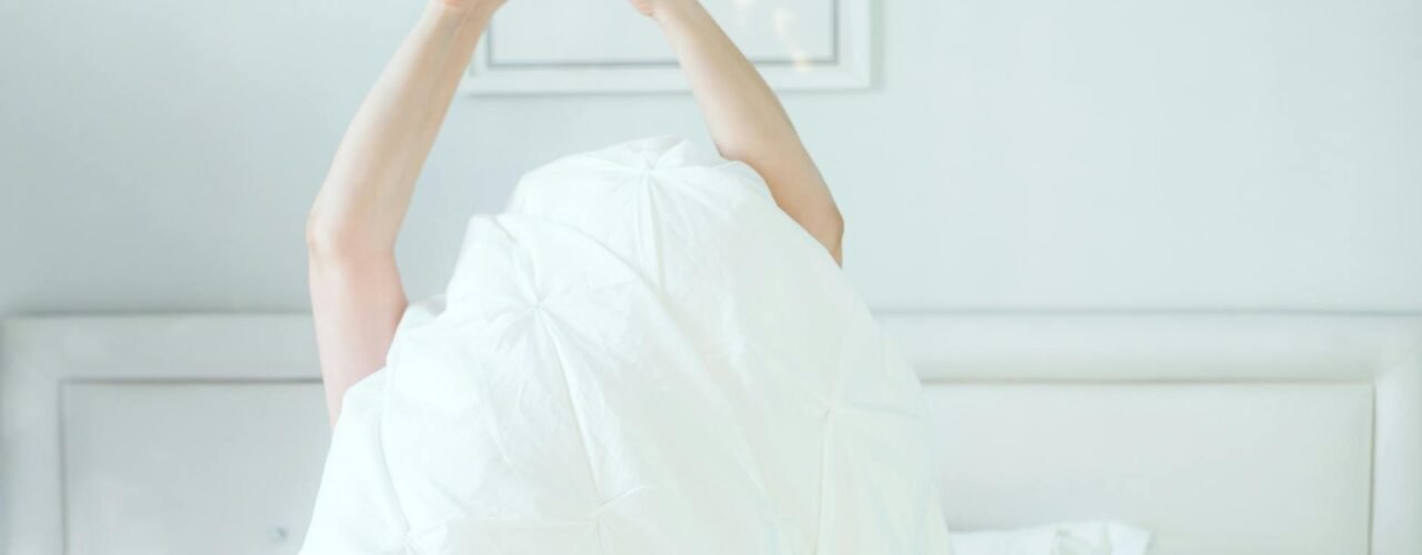 Woman stretching in sunlight during morning wellness routine at home